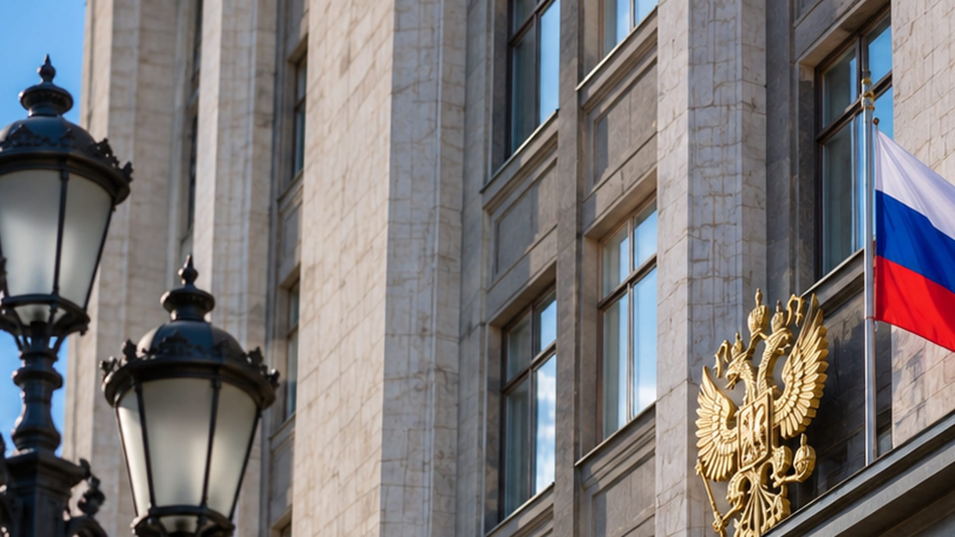 Здание Государственной думы России с государственным гербом и флагом